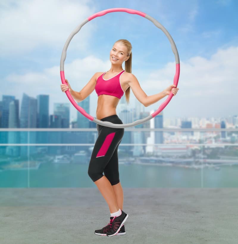 Young sporty woman wihth hula hoop