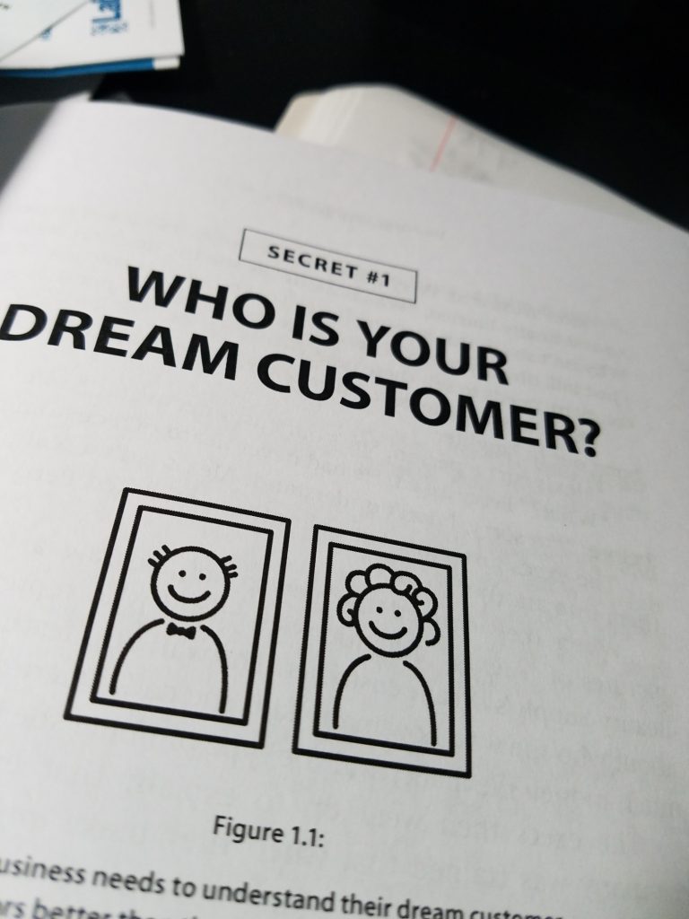Russell Brunson's Traffic Secrets book opened to the chapter about "who is your dream customer" 