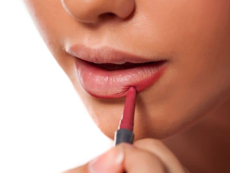 woman using lip liner to make lips appear plumper